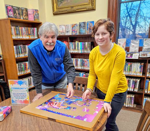 Library Director Manuel King and Teen Intern Aly Suzzi invite people of all ages to sign up for the library’s Jigsaw Puzzle Race on March 9. 