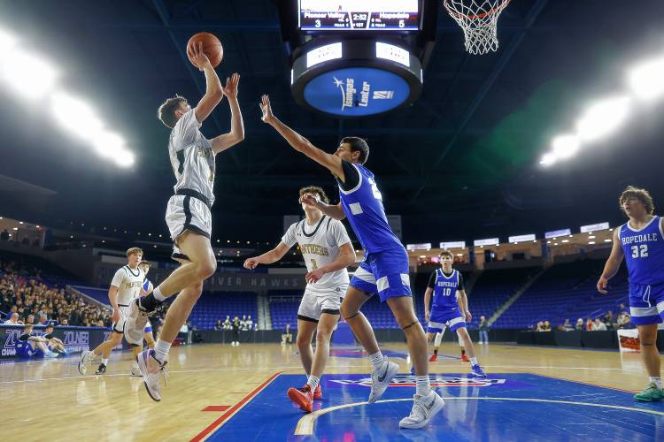 Pioneer’s Brayden Thayer (10) puts up a shot over Hopedale defender Nate Rutkowski (23) in the first quarter of the MIAA Div. 5 state championship Saturday at the Tsongas Center in Lowell. 