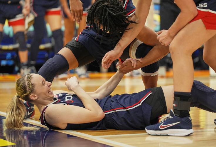 UConn guard Paige Bueckers (5) reacts as she is helped up by teammates after scoring against South Carolina during the second half of the national championship game at the Final Four of the women’s NCAA Tournament on Sunday in Tampa, Fla. 