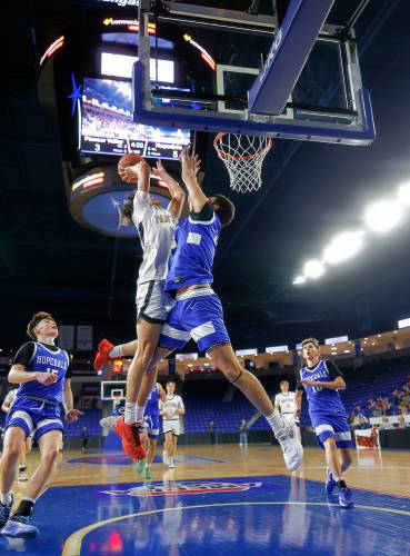 Pioneer’s Kurt Redeker (3) drives to the hoop contested by Hopedale’s Nate Rutkowski (23) in the first quarter of the MIAA Div. 5 state championship Saturday at the Tsongas Center in Lowell. 