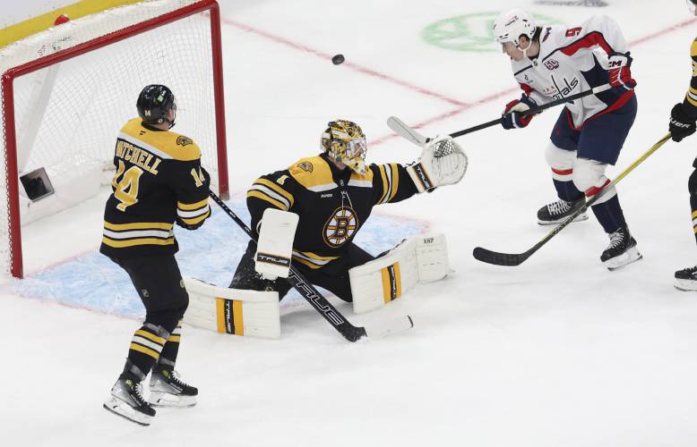Washington Capitals right wing Ryan Leonard (9) comes up short on a goal as Boston Bruins defenseman Ian Mitchell (14) and goaltender Jeremy Swayman (1) defend the net during the third period, Tuesday in Boston.