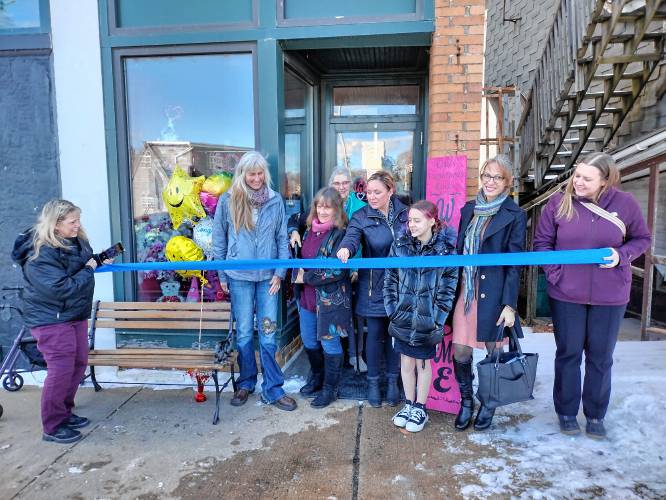 Lisa Gauthier (center) wields giant scissors to cut the ribbon officially opening her new store, The Menagerie Jewelry & Gift Shop, 74 Front St., Winchendon.